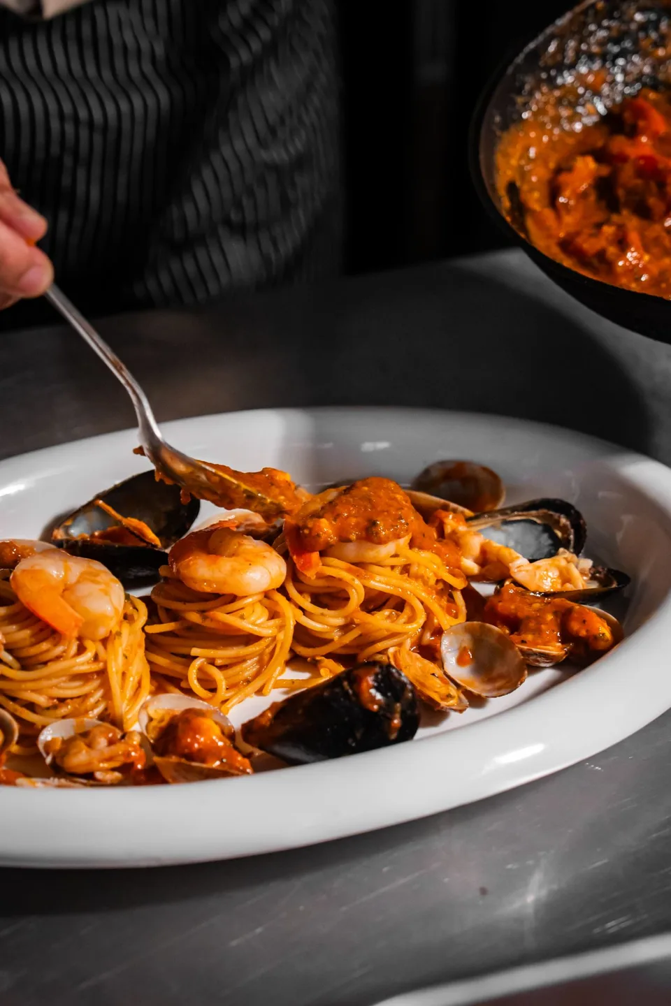 Seafood pasta and guests sharing wine at The Brick by Justwine. Photographs supplied with the restaurant brief.